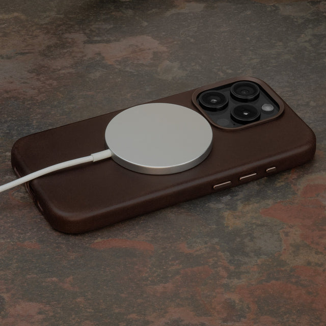 MagSafe charger attached to the Dark Brown Slimline Leather Bumper Case for iPhone 15 Pro
