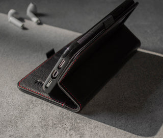 Demonstrating the integrated stand feature of the Black Leather (with Red Stitching) Stand Case for iPhone 11 Pro