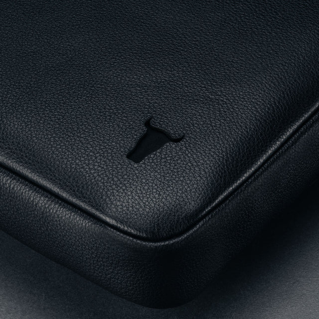 Black Leather Messenger Bag on a wooden table